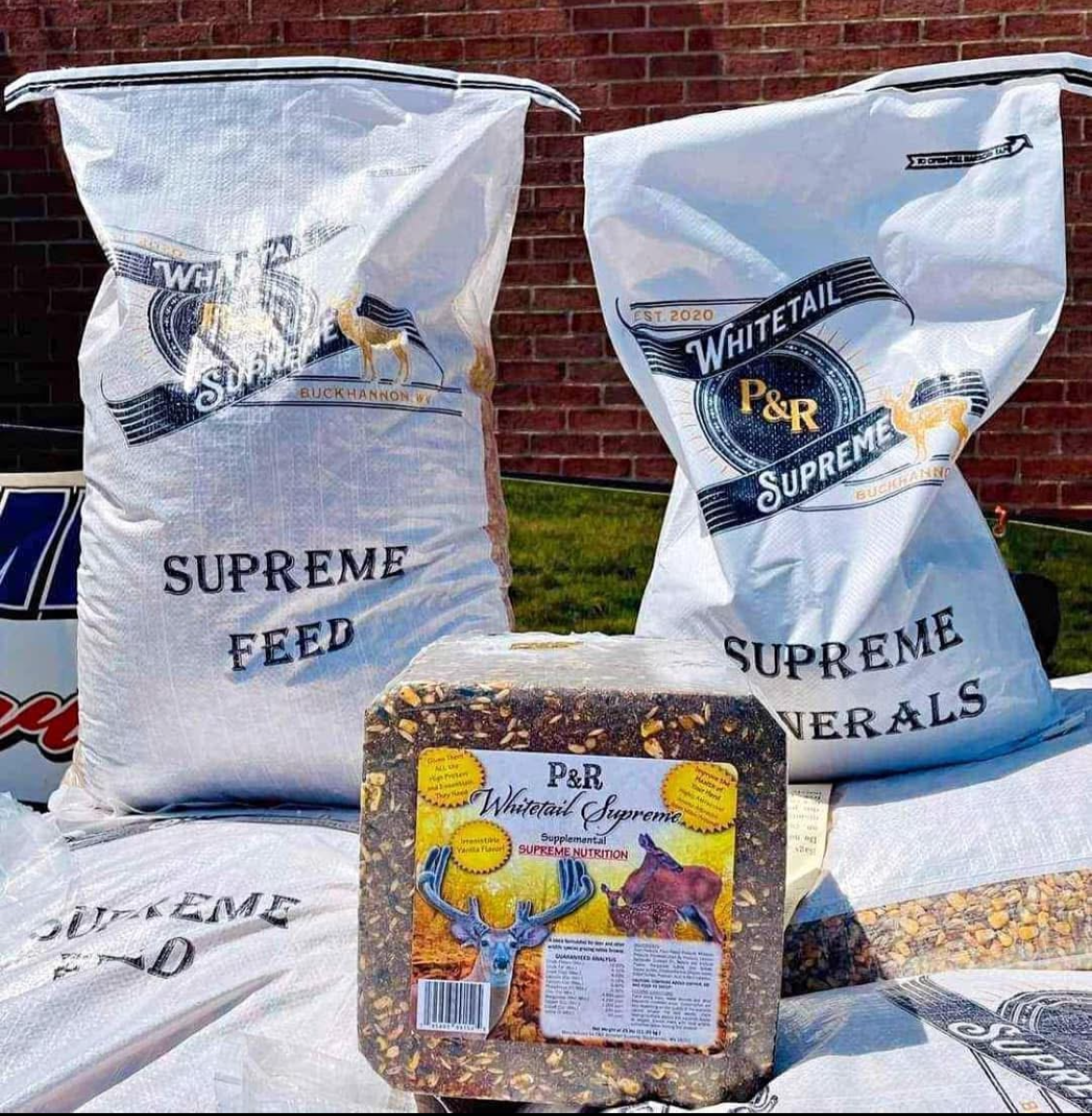 Two white bags labeled 'SUPREME WHITETAIL MINERAL' and 'P&R Whitetail Feed', with visible contents of minerals and vitamins for deer.