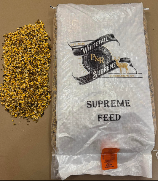 A ton of deer feed in a white bag with the label 'SUPREME DEER FEED' from P & R, alongside a pile of yellow feed pellets.